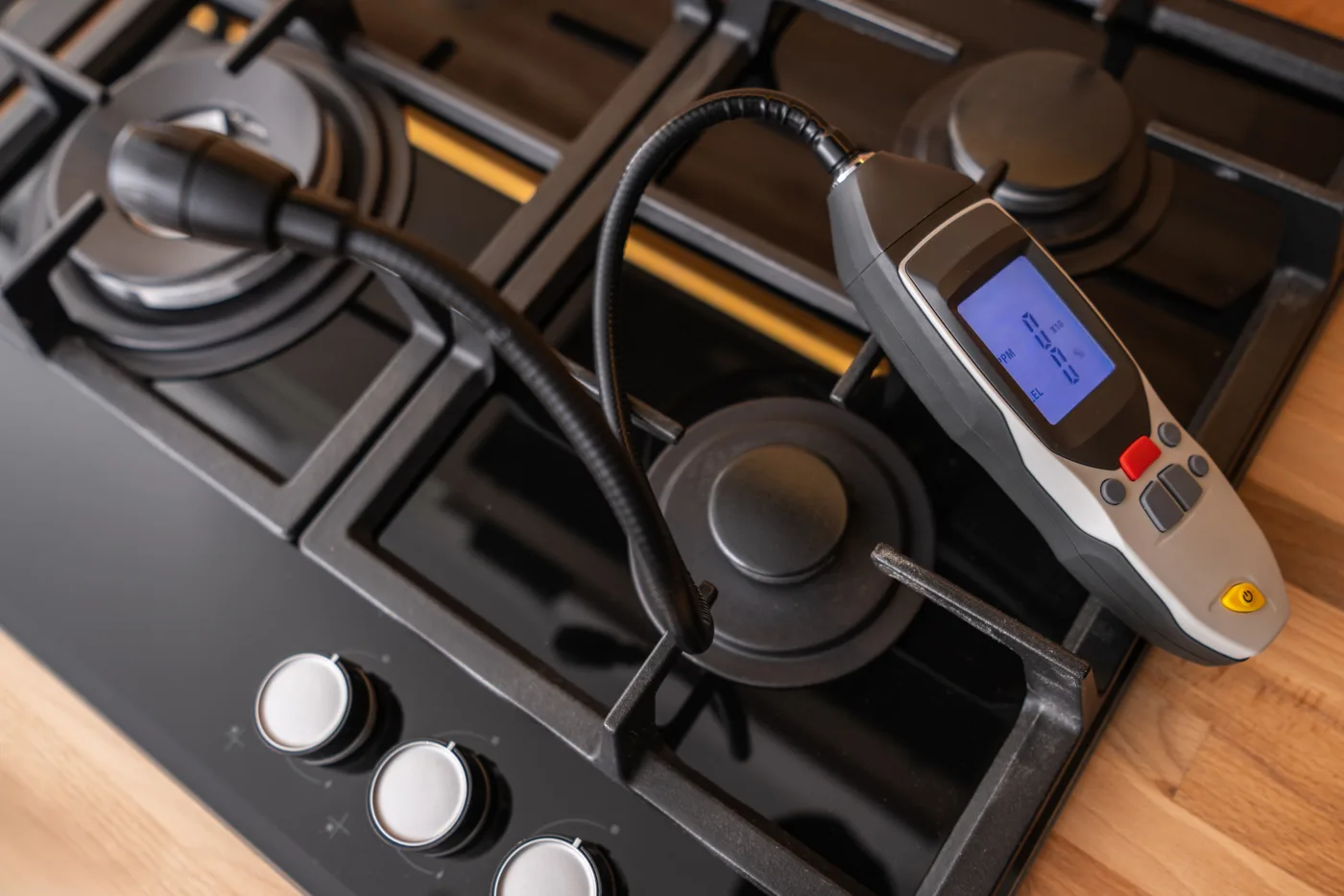 Gas leak detector testing a cooktop