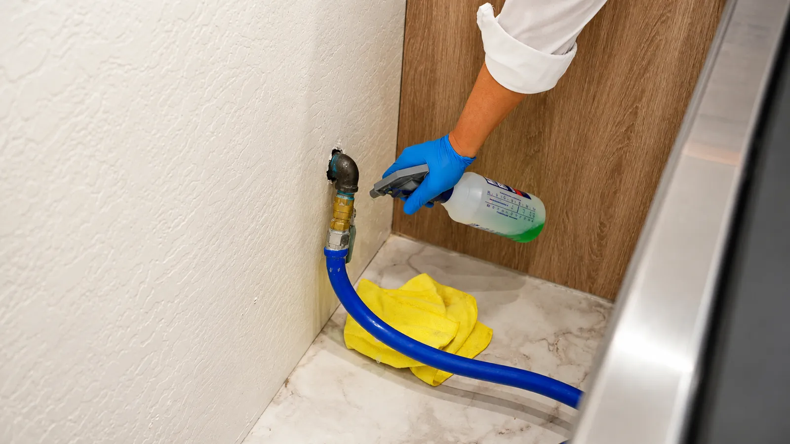 Plumber leak-testing a gas line connection