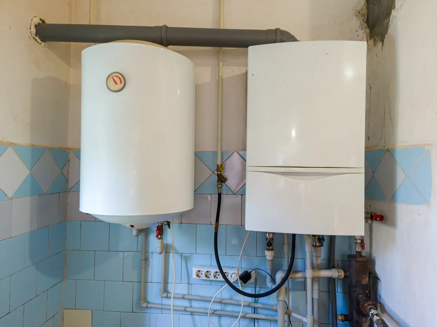 Tank and tankless water heaters mounted side by side